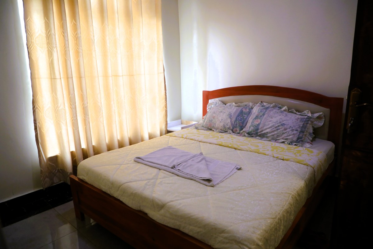 Clean tiled master bedroom with plush queen bed